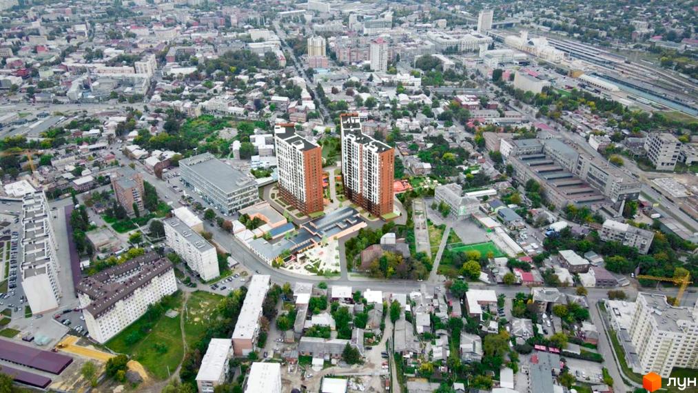 Житловий комплекс Технопарк: аерофото з двома висотними будинками з коричнево-білими фасадами, розташованими серед міської забудови та зелених зон.