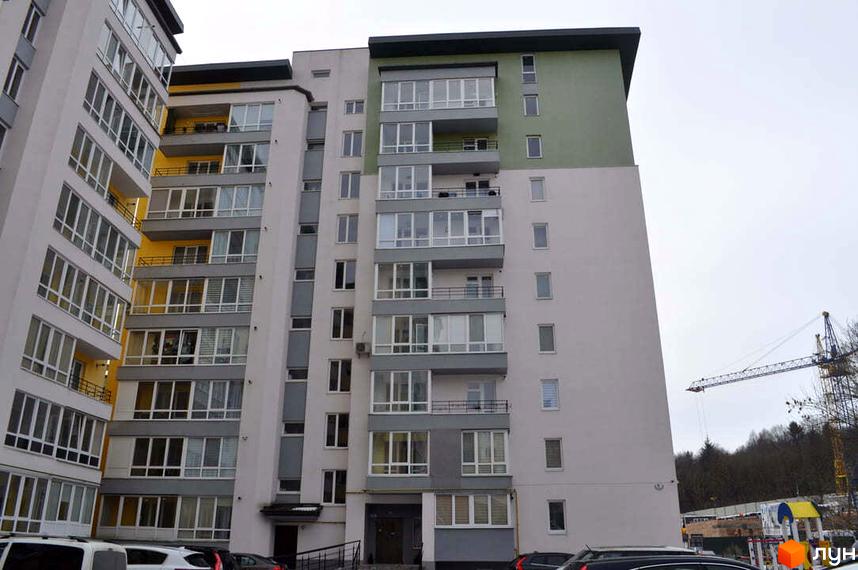 Зовнішній вигляд новобудови ЖК Монако з великою кількістю вікон та балконів. Навколо будинку видно будівельний кран та дерева.