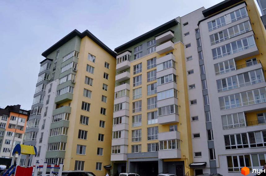 Житловий комплекс Монако. Фасад будівлі виконаний у світлих тонах з великою кількістю вікон та балконів. Поруч розташований дитячий майданчик.