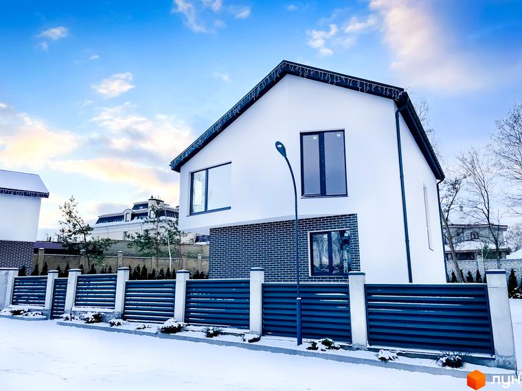 Котеджне містечко КМ Friends Club. Білий двоповерховий будинок з темною цегляною обробкою та великими вікнами, огороджений парканом, на тлі зимового пейзажу.