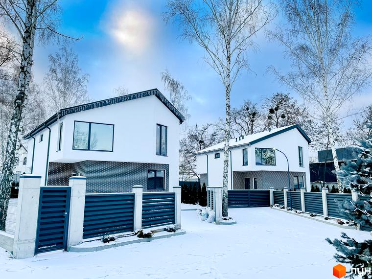 Котеджне містечко КМ Friends Club. Сучасні двоповерхові будинки з білою штукатуркою та сірою цеглою, розташовані серед дерев у зимовий період.