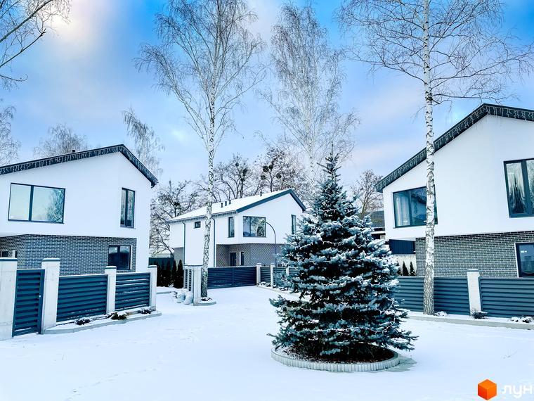 Котеджне містечко КМ Friends Club. Сучасні білі будинки з панорамними вікнами та зеленою ялинкою на подвір'ї взимку.
