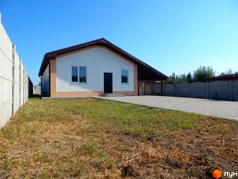 Одноповерховий будинок з темним дахом та двома вікнами. Перед будинком газон та вимощена доріжка, збоку бетонний паркан.