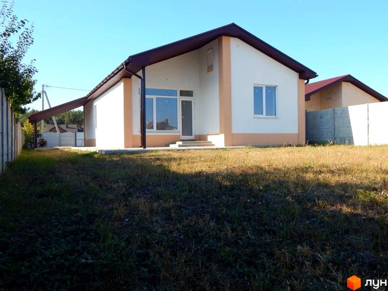 Одноповерховий будинок з білими стінами та коричневим дахом у Містечку котеджів Черкаські Тишки. На передньому плані газон з травою, на задньому - паркан та інші будинки.
