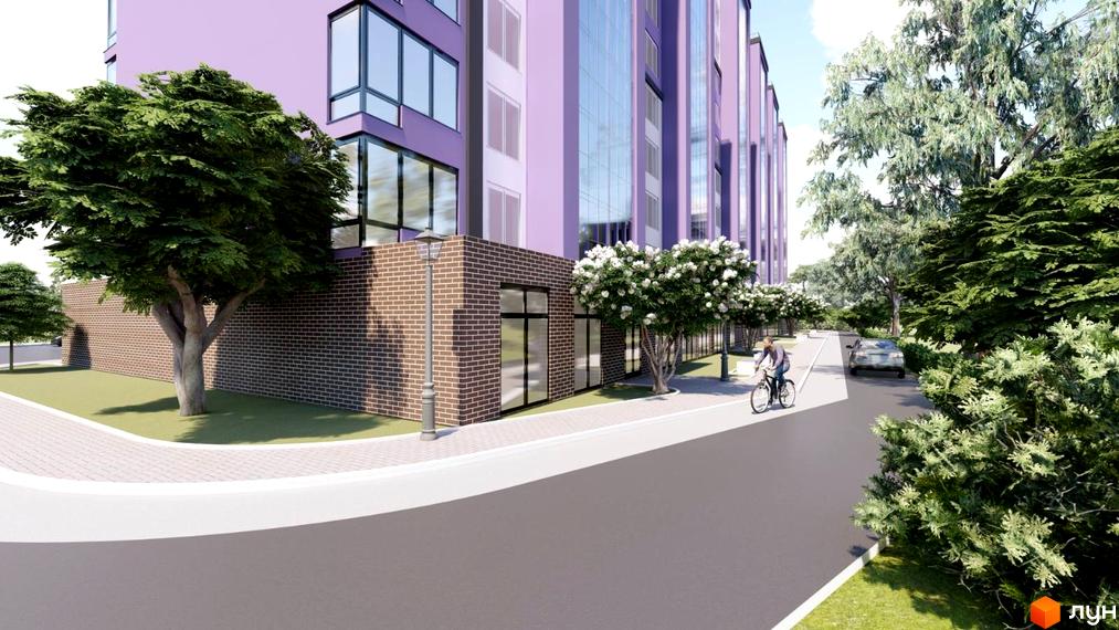 Зовнішній вигляд будинку ЖК Колорит з фіолетовим фасадом, великими вікнами та цегляною облицовкою нижнього поверху. Поруч розташована прибудинкова територія з деревами, пішохідною доріжкою та велосипедною доріжкою.