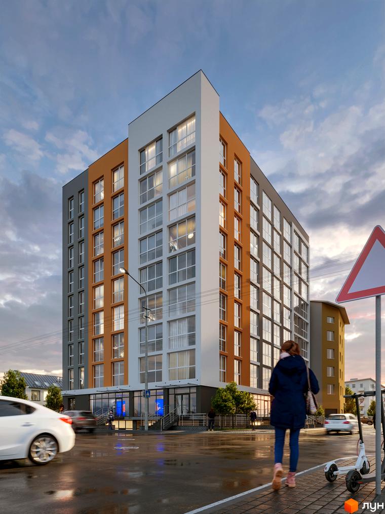 Фасад житлового комплексу Затишний з панорамними вікнами та оранжевими елементами. Поруч розташована доглянута прибудинкова територія з тротуаром та електросамокатами.