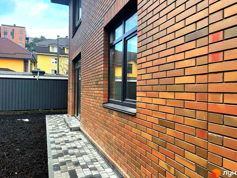 Котеджне містечко КМ Дубовий Гай: фасади будинків з цегли та вимощені доріжки прибудинкової території.