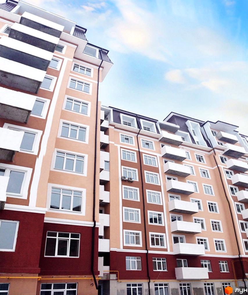 Житловий комплекс Варшавський двір з фасадом у світлих тонах та балконами. Прибудинкова територія з зеленими насадженнями.