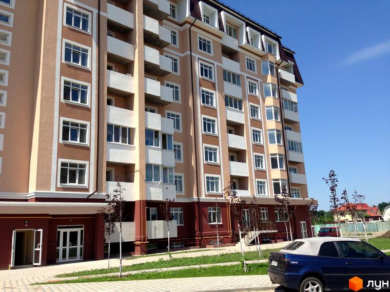 Житловий комплекс Варшавський двір з фасадом, великими вікнами та прибудинковою територією з зеленими насадженнями.