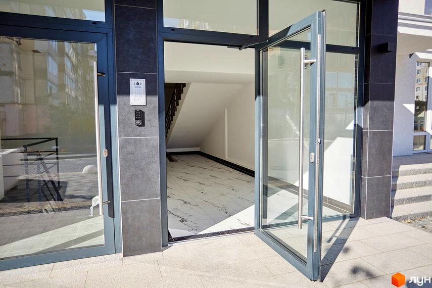 Вхідна група в Житловий комплекс KromaxBud з великими скляними дверима. Вигляд на сходову клітку та оздоблення плиткою.
