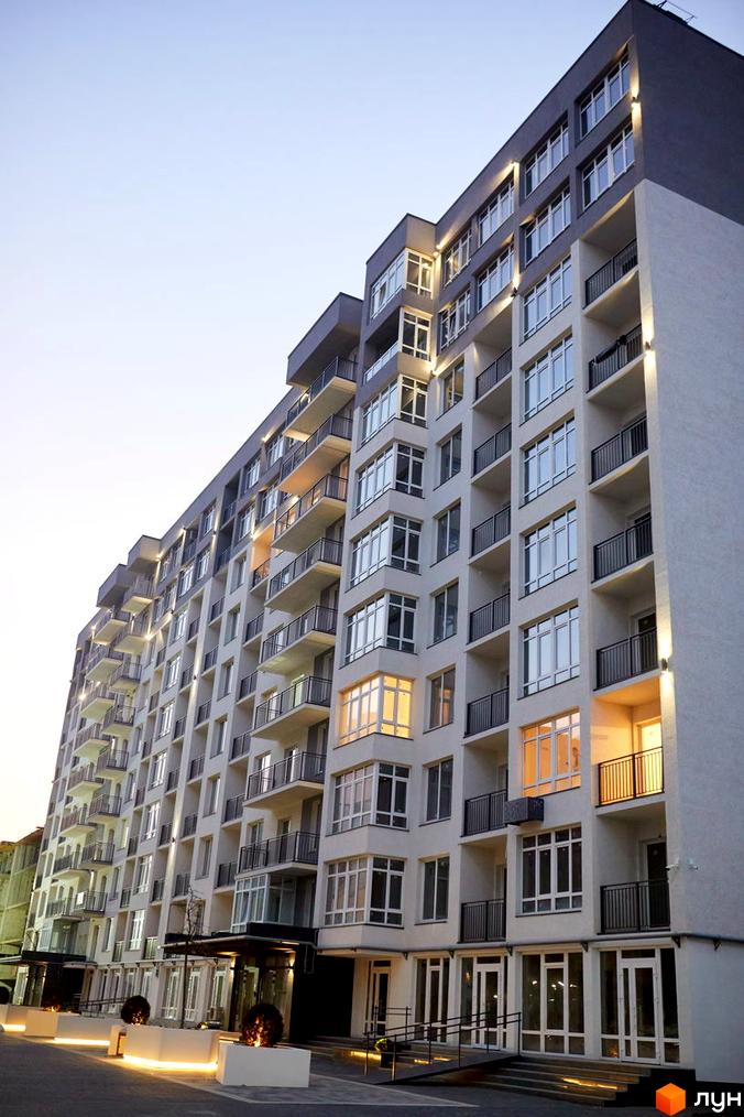 Зображення фасаду багатоповерхового будинку в Житловому комплексі KromaxBud. Вигляд новобудови з великими вікнами та балконами.