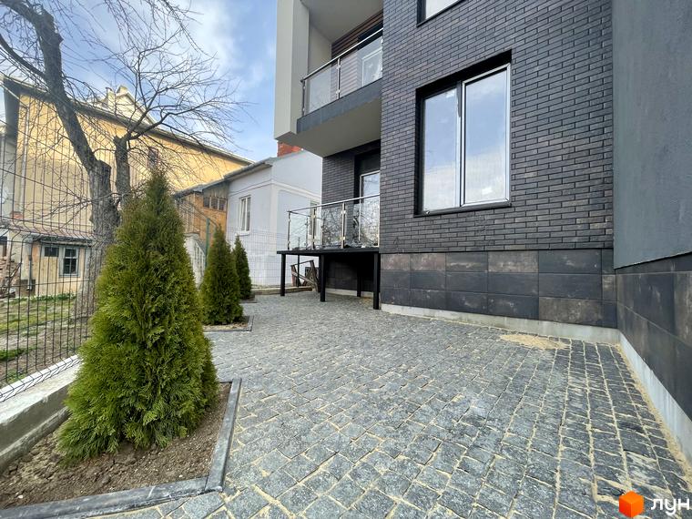 Вигляд фасаду будинку та прибудинкової території Житлового комплексу Elite House. На подвір'ї висаджені декоративні дерева.