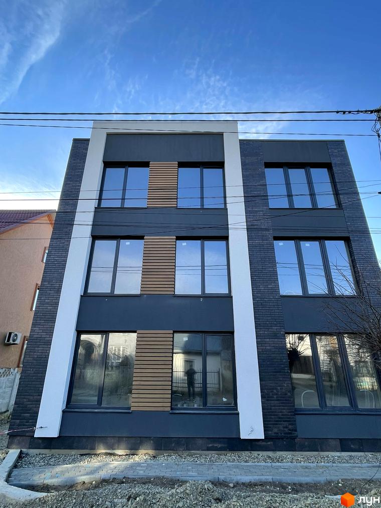 Зовнішній вигляд будинку в Житловому комплексі Elite House. Багатоповерхова будівля з великими вікнами та оздобленням фасаду.