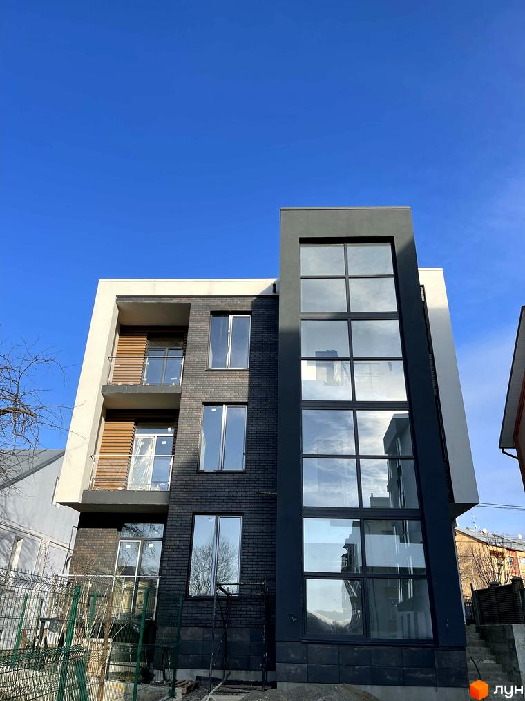 Зображення фасаду та скління Житлового комплексу Elite House. Вигляд новобудови ззовні на фоні блакитного неба.