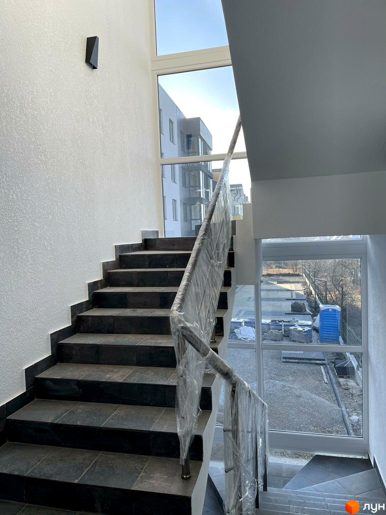 Фото сходів у Житловому комплексі Elite House з великими вікнами та видом на прибудинкову територію.