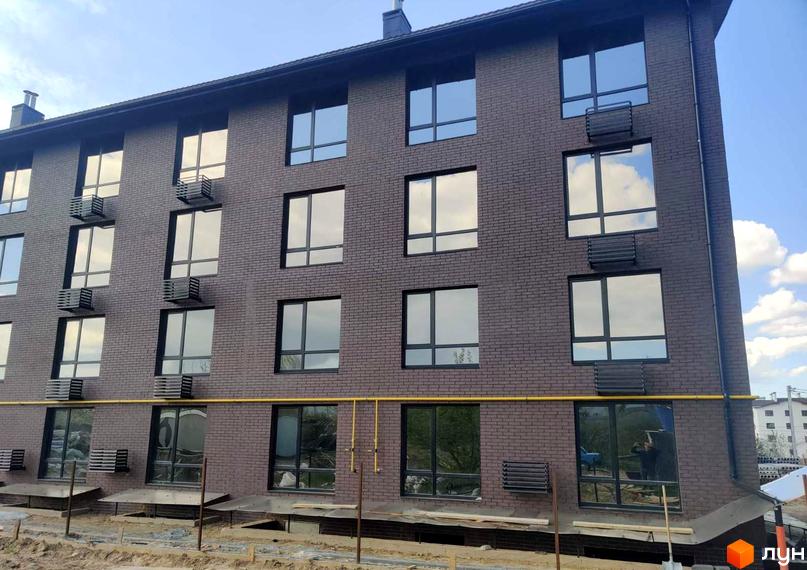 Зовнішній вигляд фасаду будинку Житлового комплексу Моя Баварія з великими вікнами та кондиціонерами.