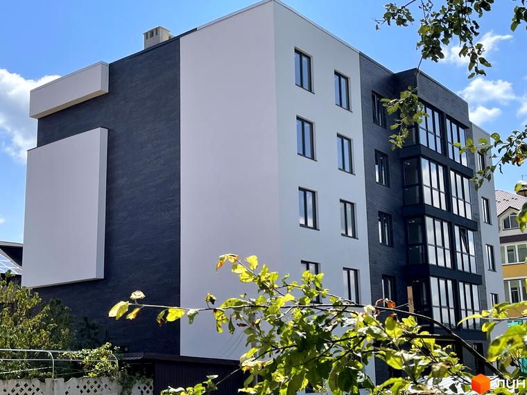 Зовнішній вигляд новобудови ЖК Center з білими та темно-сірими фасадами, великими вікнами та елементами озеленення.