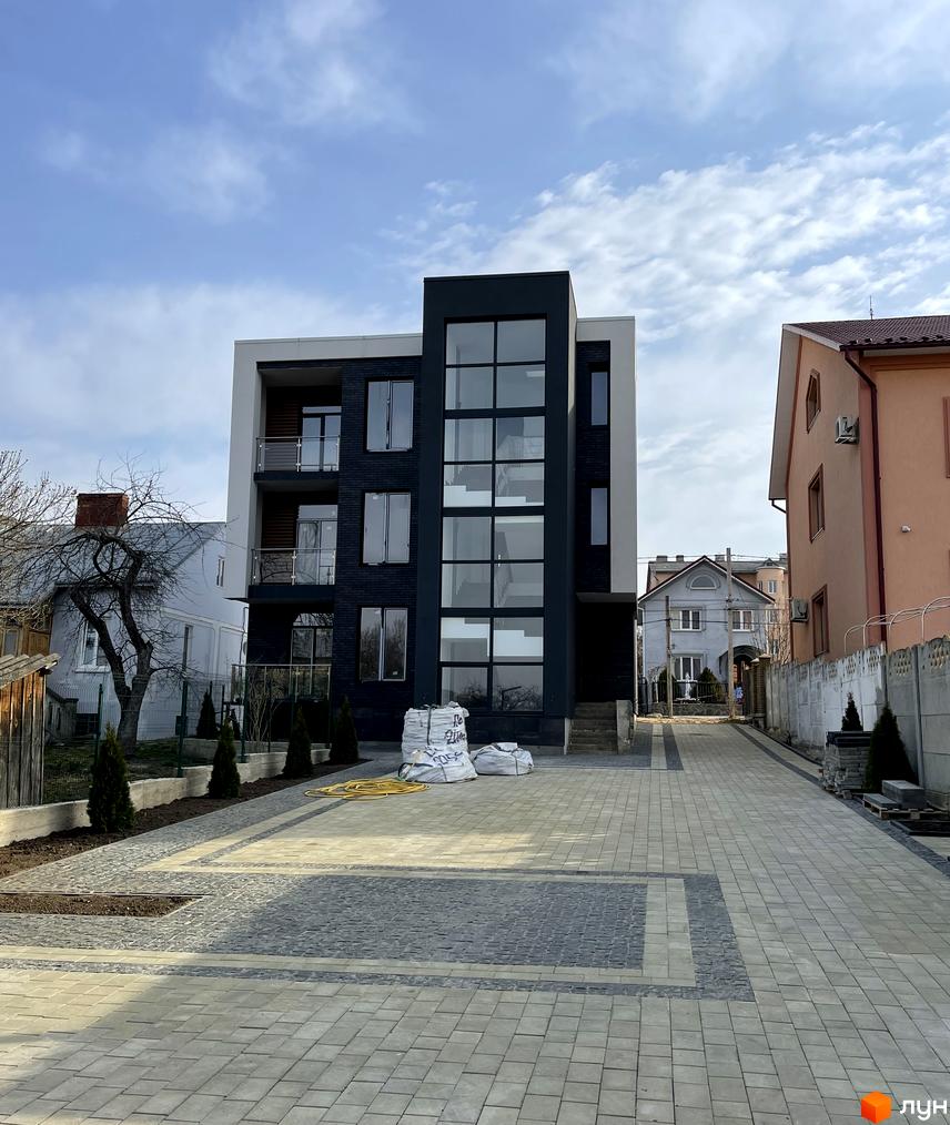 Вигляд фасаду та прибудинкової території Житлового комплексу Elite House. На передньому плані викладена бруківкою дорога.