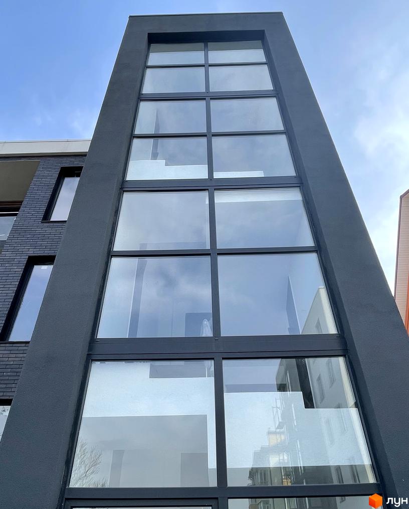 Зовнішній вигляд будинку в Житловому комплексі Elite House з великими вікнами. Вигляд знизу вгору на фасад.