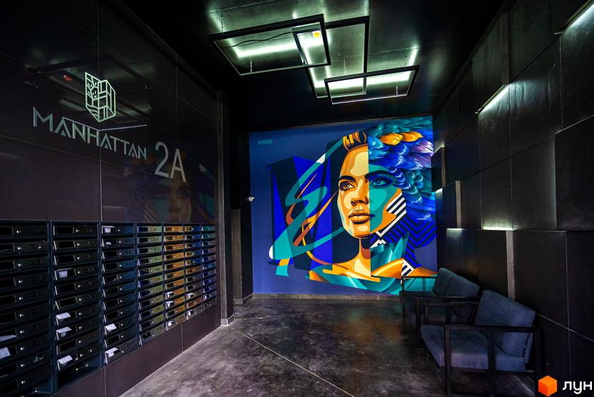 Житловий район Manhattan 2A: сучасний вхід з поштовими скриньками та яскравим муралом. Ознайомтеся з дизайном новобудови Manhattan 2A.