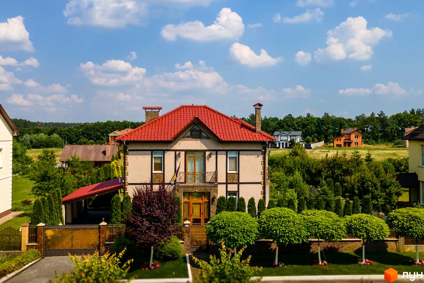 Котеджне містечко Home Resort: двоповерховий будинок з червоним дахом та доглянутою прибудинковою територією з зеленими деревами та воротами.