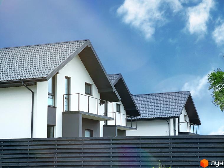 Зображення котеджів в Містечку котеджів Green Hill Village з білими фасадами та темними дахами, огороджених дерев'яним парканом.