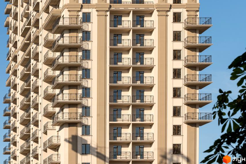 Зовнішній вигляд багатоповерхового будинку з балконами у Житловому комплексі Акрополь. Фасад будівлі з великою кількістю вікон.