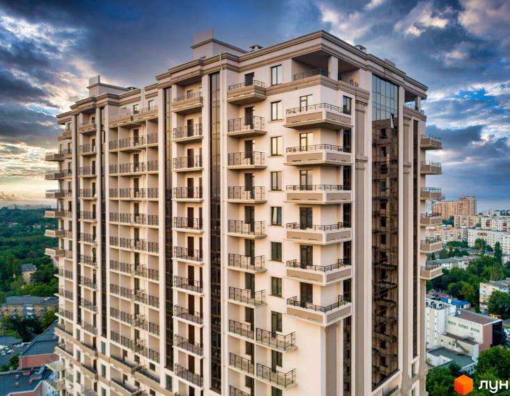 Зображення багатоповерхового будинку в Житловому комплексі Acropol. Вигляд фасаду з балконами та панорамними вікнами на тлі міського пейзажу.