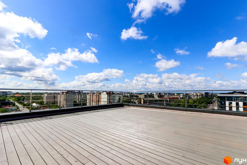 Вид з тераси житлового комплексу Park Residence на місто. Відкривається панорама міської забудови та блакитне небо з хмарами.
