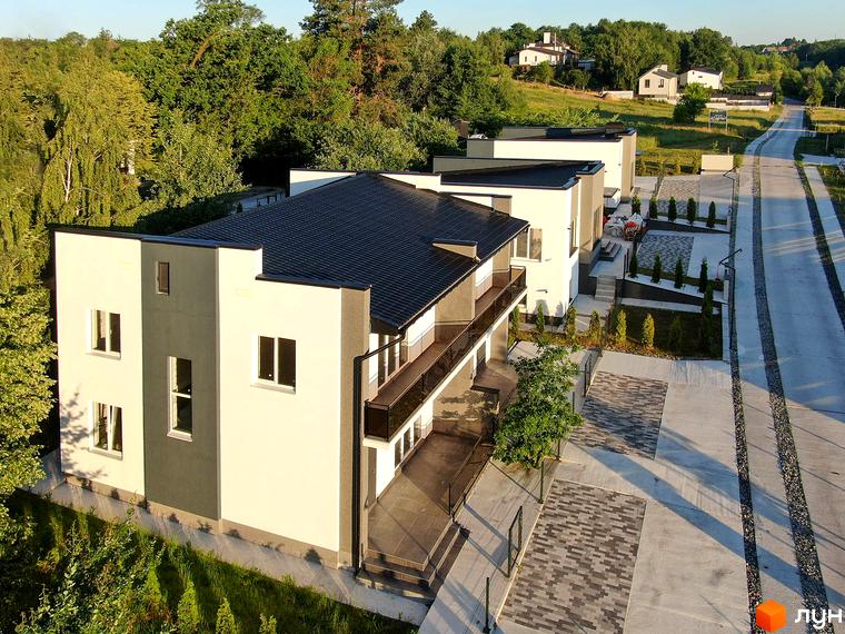 Котеджне містечко Терещенські Озера: фасади будинків з темним дахом та прибудинкова територія з бруківкою та деревами.