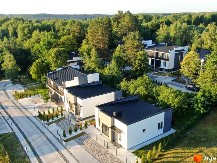 Котеджне містечко Терещенські Озера: сучасні будинки з чорними дахами та прибудинковою територією з бруківкою та зеленими насадженнями.