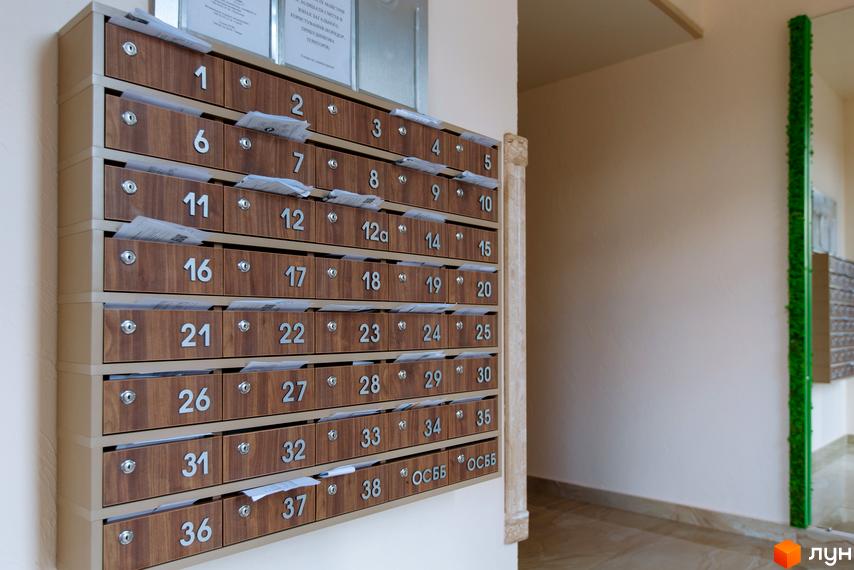 Секція поштових скриньок з номерами в житловому комплексі SilverPark. На скриньках видно папери, що свідчить про їх використання.