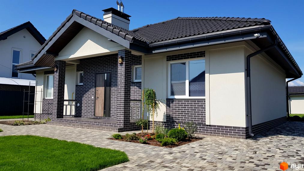 Котеджне містечко КМ Сонячний: одноповерховий будинок з темною цегляною обробкою та світлими стінами, з доглянутою прибудинковою територією та бруківкою.