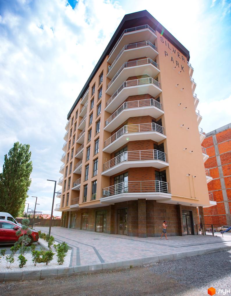 Новобудова Silver Park з численними балконами та сучасним фасадом. На прибудинковій території розташовані зелені насадження та паркувальні місця.