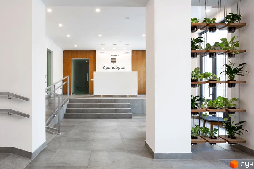 Сучасний інтер'єр приймальні житлового комплексу Крайобраз з рецепцією та зоною очікування. Вертикальне озеленення створює затишну атмосферу.