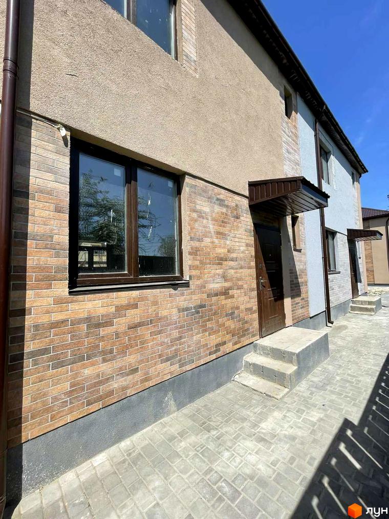 Зовнішній вигляд будинку Comfort home з цегляною кладкою та великими вікнами. Перед будинком викладена бруківка, є сходи до входу.