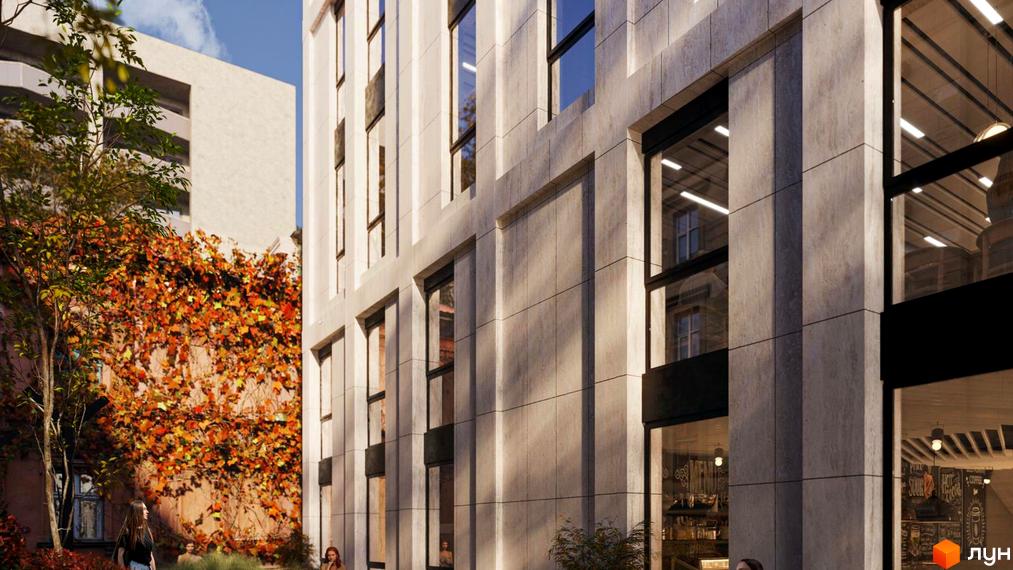 Клубний будинок Dmytrivsky з фасадом з світлого каменю та великими вікнами, поруч зелена зона з деревами та осіннім листям.