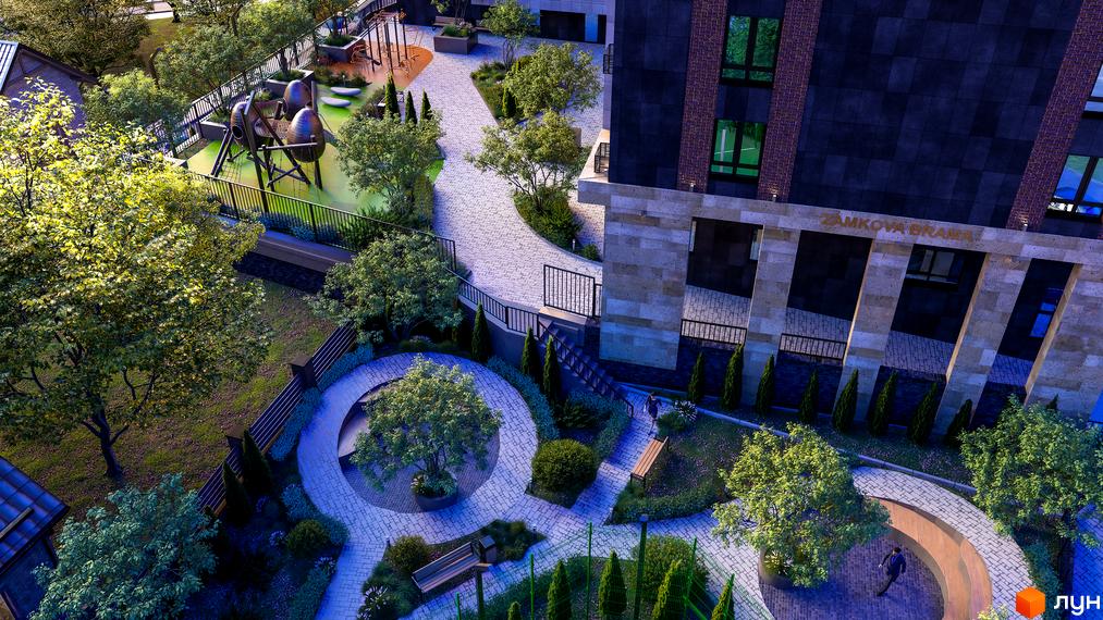 Вигляд зверху на Житловий комплекс Замкова Брама з дитячим майданчиком та пішохідними алеями. Фасад будинку оздоблено темною плиткою.