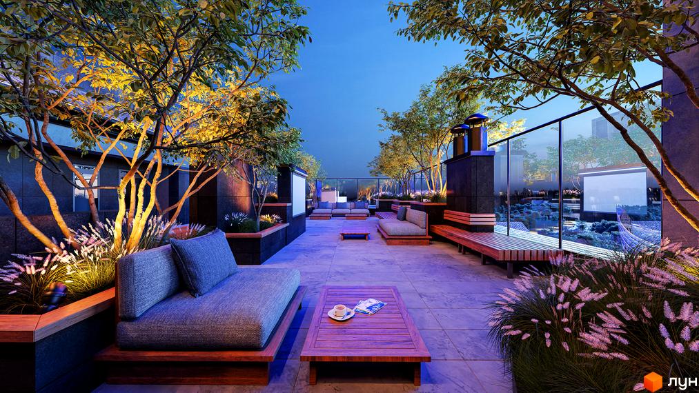 Зображення тераси на даху Житлового комплексу Замкова Брама з м'якими меблями, деревами та видом на місто вночі.