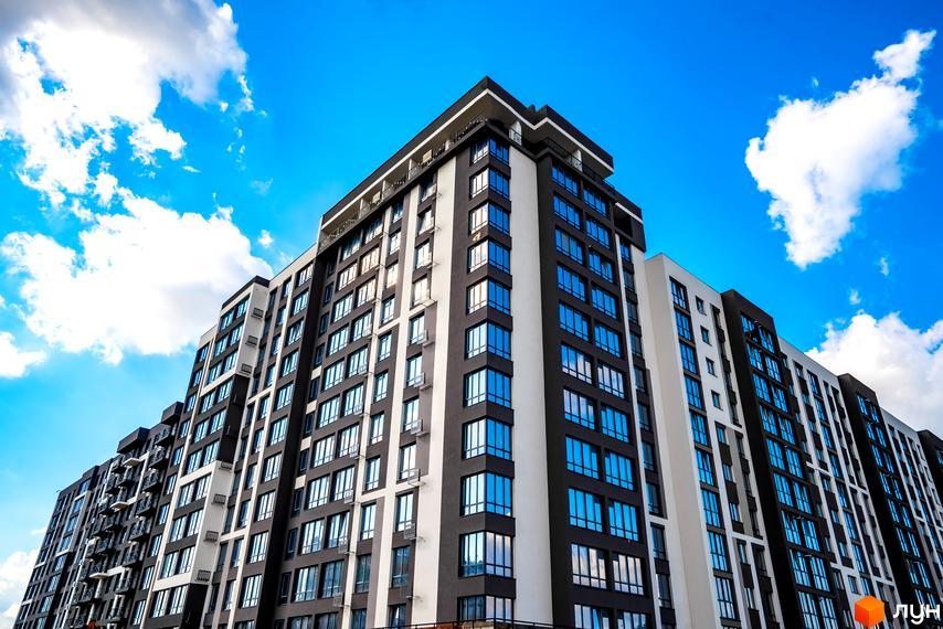Зображення багатоповерхового будинку Житловий комплекс Паркова Алея з великими вікнами на фоні блакитного неба. Вигляд фасаду та архітектури.