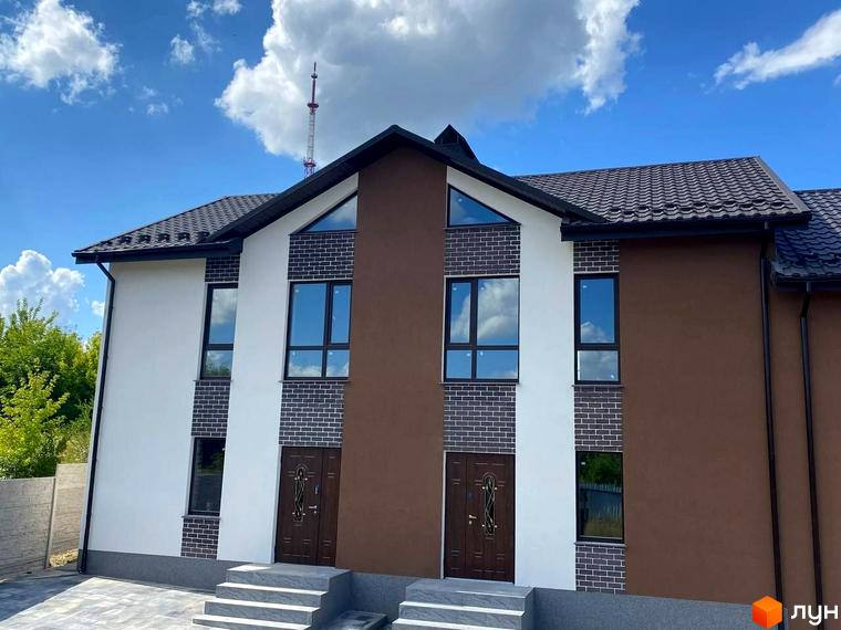 Фасад таунхаусів Dream Town 3: двоповерхові будинки з коричневим дахом, білими, коричневими стінами та цегляними елементами. Перед будинками вимощена територія.