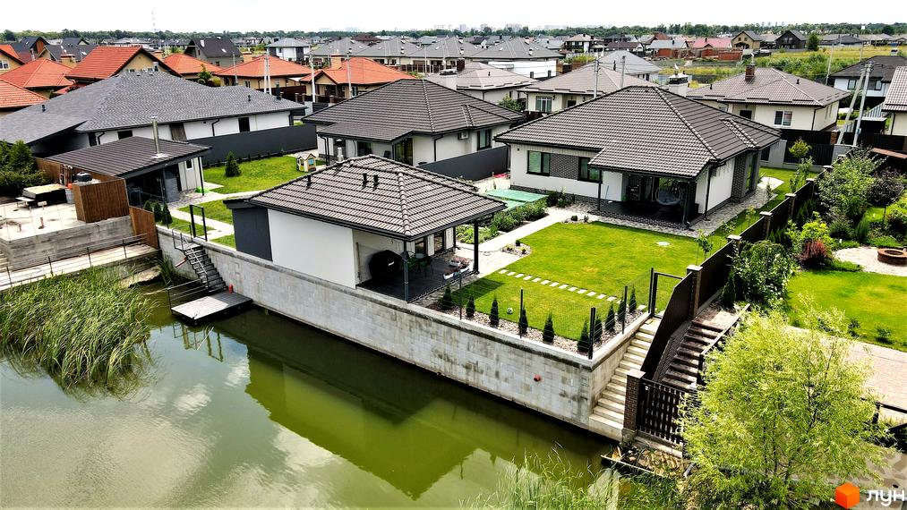 Котеджне містечко Сонячний: сучасні будинки з доглянутими прибудинковими територіями та виходом до води. Оглядовий вид на житловий комплекс та його інфраструктуру.