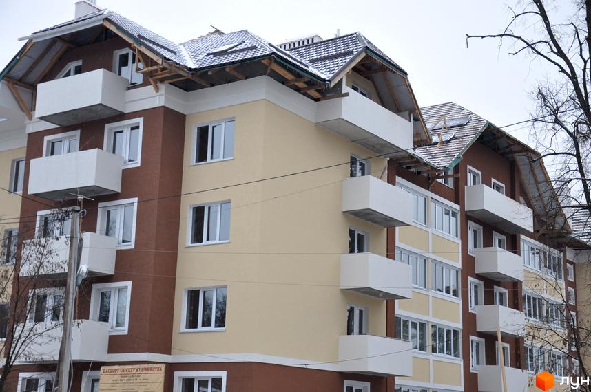 Зовнішній вигляд новобудови на вул. Університетська, 16 з балконами та сучасною фасадною обробкою, прибудинкова територія з деревами.