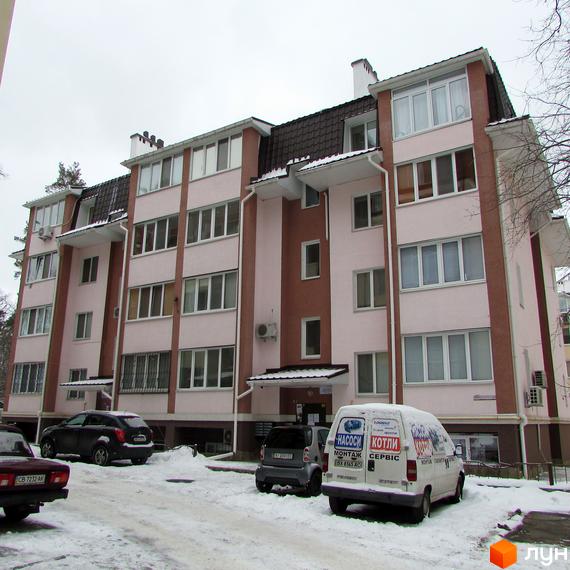 Житловий комплекс на вул. Лермонтова, 6д, з фасадом у світлих тонах та прибудинковою територією, засніженою взимку.