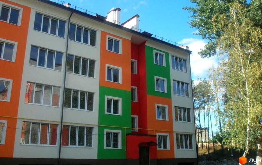 Зовнішній вигляд будинку житлового комплексу ЖК Ягода з яскравими кольоровими фасадами та прибудинковою територією.