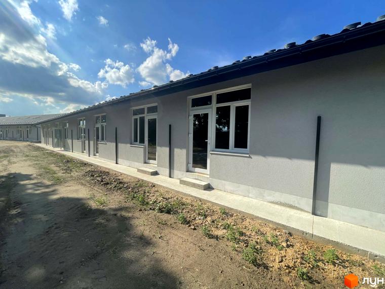 Зовнішній вигляд таунхаусів Оак-Парк з сірим фасадом та великими вікнами. Поруч облаштована прибудинкова територія з доріжкою.