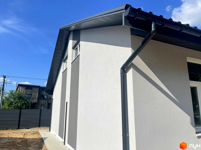 Таунхауси Оак-Парк: фасад будинку з сірими та білими елементами під сірим дахом, поруч паркан та зелень.