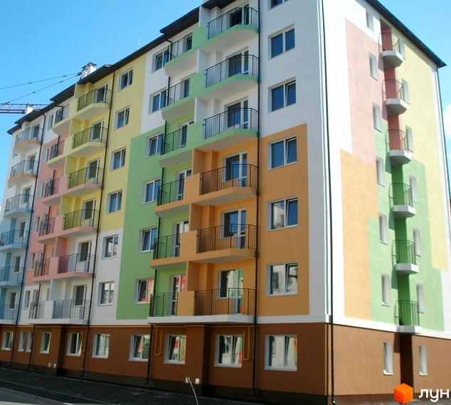 Житловий комплекс Ягода з яскравими фасадами та балконами. Прибудинкова територія з зеленими насадженнями та асфальтованими доріжками.