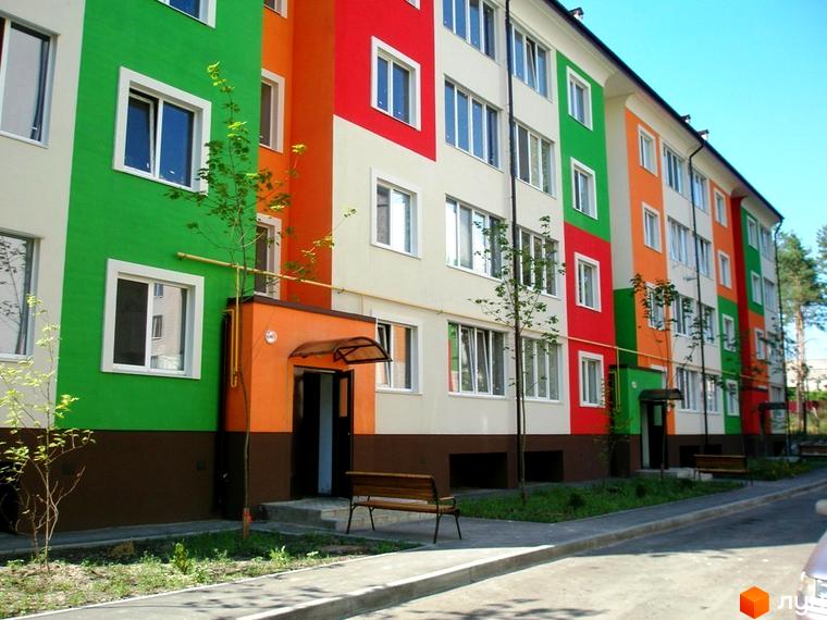 Житловий комплекс ЖК Ягода з яскравими кольоровими фасадами. Прибудинкова територія з зеленими насадженнями та лавками.