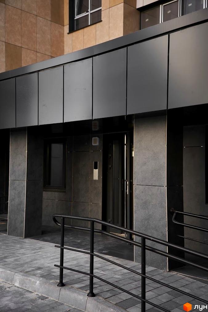 Фасад будинку в Житловому комплексі Оселя Парк з вхідною групою та пандусом. Вигляд новобудови та прилеглої території.